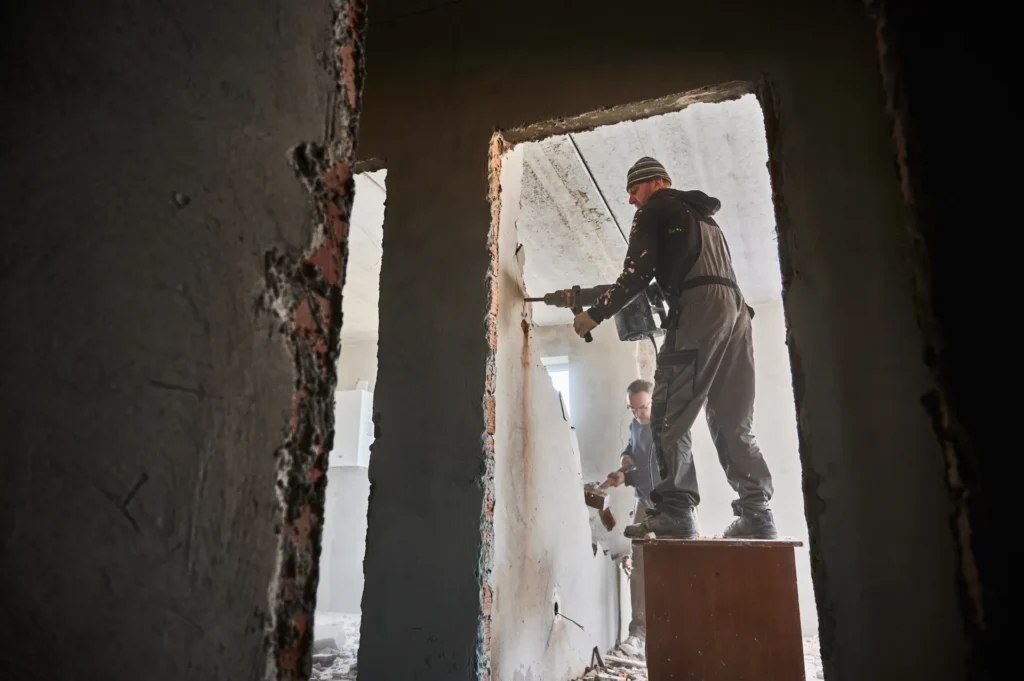 Professional team demolishing an interior wall.
